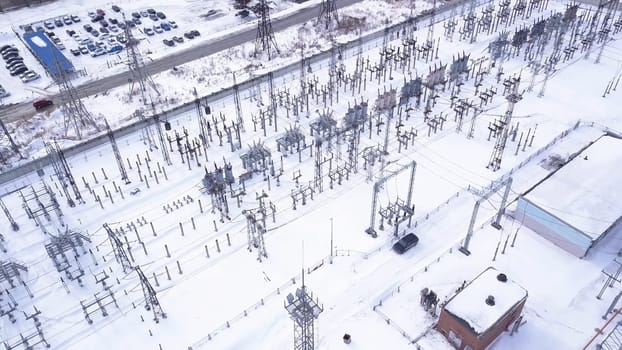 Top view of electric city substation. Action. Electrical substation with transformers distributing high voltage throughout city. Suburban electric substation in winter. Electric power industry