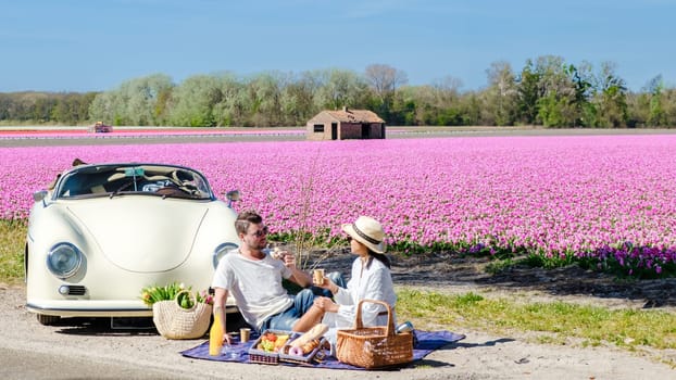 couple on a roadtrip in the Netherlands with a old vintage car