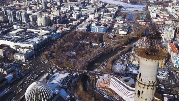 Aerial view on abandoned TV tower in Yekaterinburg. Clip. Aerial view of abandoned, old building, TV tover or communication tower with city landscape background.