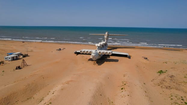 Old plane on beach. Action. Military plane landed on coast of sea many years ago. Abandoned military plane on seashore with history
