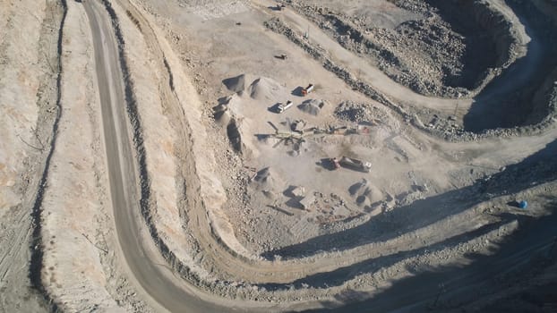 Top view of sand quarry with excavators. Shot. Open pit mining operations with operating excavators. Mining industry concept