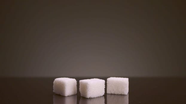 Pile of sugar cubes on isolated background. Stock footage. Pile of sugar cubes changes in number on isolated background. Sweets in large quantities are harmful to health. Sugar and sweets are 21st century addiction