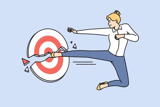 Business woman kicks target showing strength and ambition to achieve goals and complete task