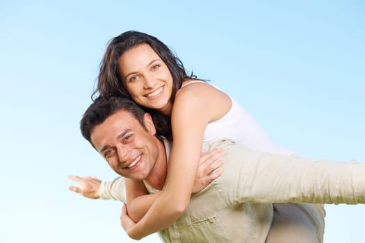 Happy couple, portrait and piggyback with love, marriage and enjoying a break on holiday, smile and funny. Playful, vacation and honeymoon for having fun, carefree and romantic relationship
