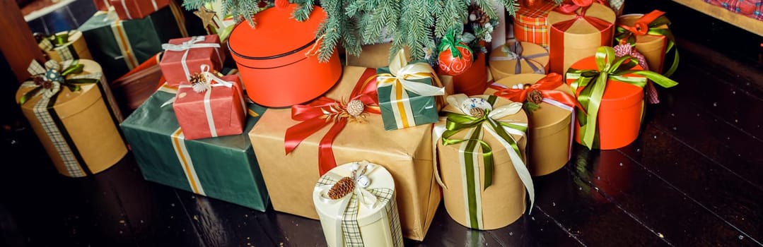 Christmas background with many gift boxes decorated with ribbon on floor under Christmas tree. Winter holidays concept. stack of Boxes with gifts under the Christmas tree