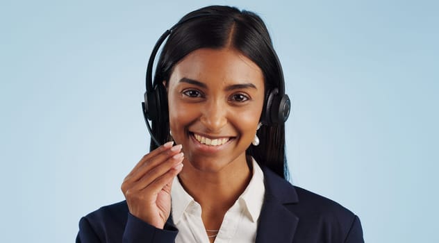 Happy woman, portrait and headphones for call center or customer service against a blue studio background. Face of female person, consultant or agent smile with mic for online advice on mockup space
