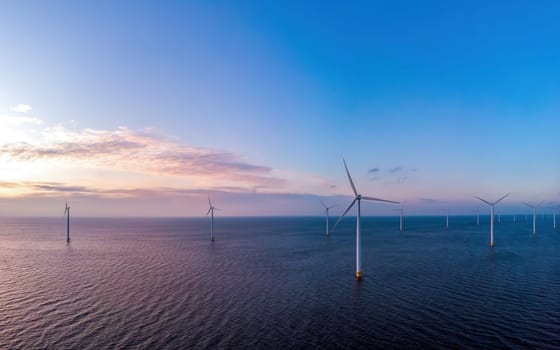 Windmill turbines at sea seen from a drone aerial view from above