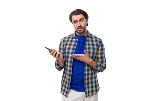 smart brunette macho man with a beard and mustache in a blue shirt on a white background with copy space