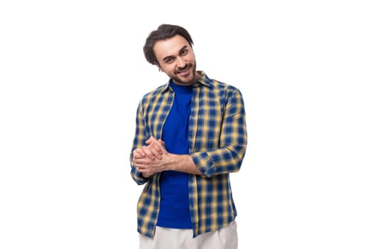 stylish well-groomed brunette macho man with a beard and mustache in a blue shirt