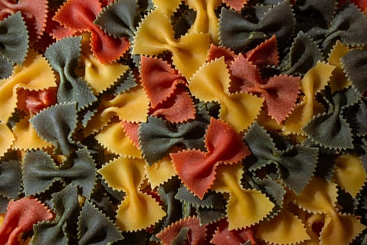 Dry Uncooked Colored Farfalle Pasta and Raw Macaroni on a Textured Background