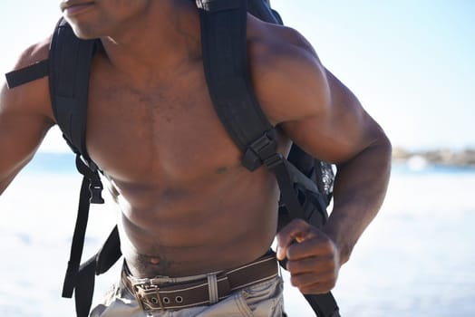 Backpack, running and muscular black man on beach for workout, exercise or outdoor cardio by ocean coast. Closeup of African male person on run with bag for adventure or training by the sea in nature