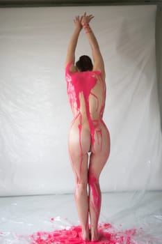 young beautiful woman posing nude painted with paint