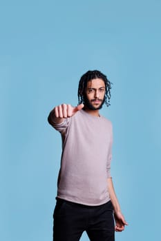 Cool arab man showing neutral thumb sign with hand
