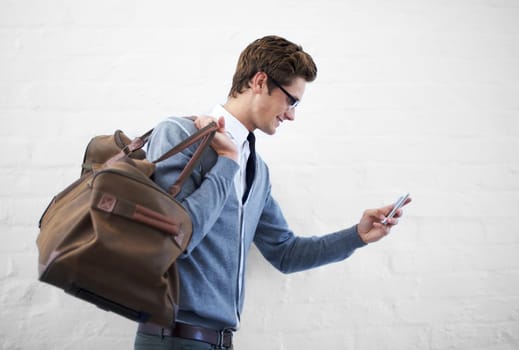 Business man, bag and phone by wall background with click for booking app, schedule and happy on travel. Entrepreneur, employee and smartphone for smile, reading and scroll on web for flight schedule