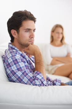 Man, angry and living room couch with disagreement, upset and thinking with anger, fight or mad. Divorce, betrayal and relationship with cheating, stress and argument for marriage, home and woman