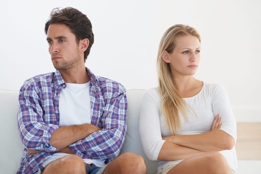 Couple, angry and living room couch with disagreement, upset and thinking with anger, fight or mad. Divorce, betrayal and relationship with cheating, stress and argument for marriage, home or toxic