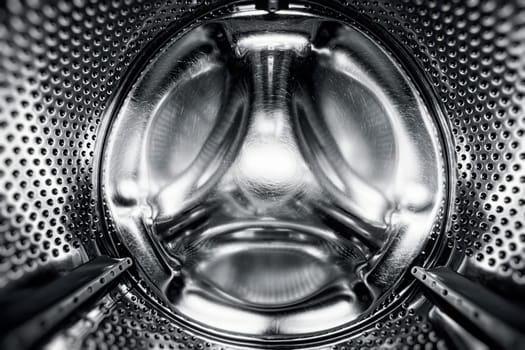 Washing Dryer Machine inside view. Washing machine drum, view from the inside. Metal drum of a washing machine. Abstract home background. Inside of washing machine
