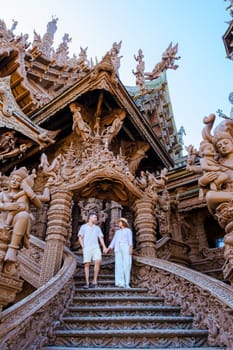 A couple visit The Sanctuary of Truth wooden temple in Pattaya Thailand