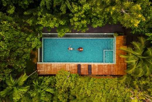 aerial view of swimming pool in the jungle of Krabi Thailand, couple in pool, men and woman in pool