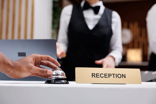Tourist using service bell at front desk