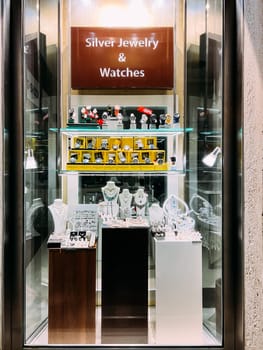 Showcase of a jewelry store with jewelry on pedestals. Caption: Silver jewelry and watches. High quality photo