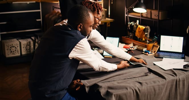 African american tailors cutting garment