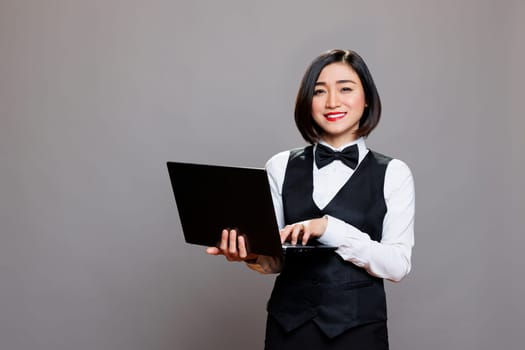 Asian waitress typing on laptop portrait