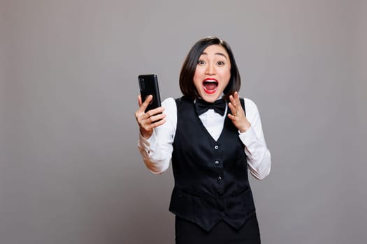 Excited waitress holding smartphone