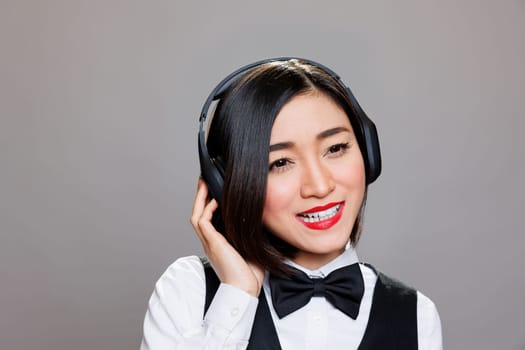 Smiling asian waitress in headphones