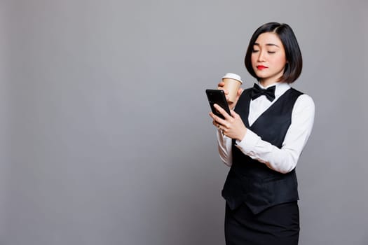 Waitress drinking coffee and using phone