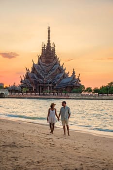 A couple visit The Sanctuary of Truth wooden temple in Pattaya Thailand