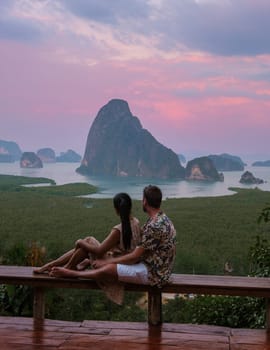 Couple watching sunrise at Sametnangshe viewpoint of mountains in Phangnga bay Thailand