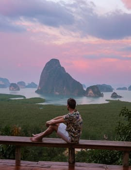 a man watching sunrise at Sametnangshe viewpoint of mountains in Phangnga bay Thailand