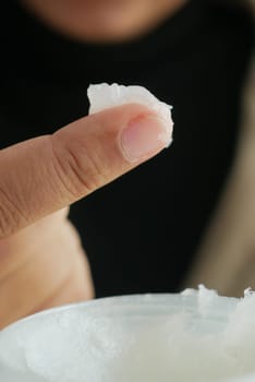 woman using petroleum jelly onto skin at home close up.