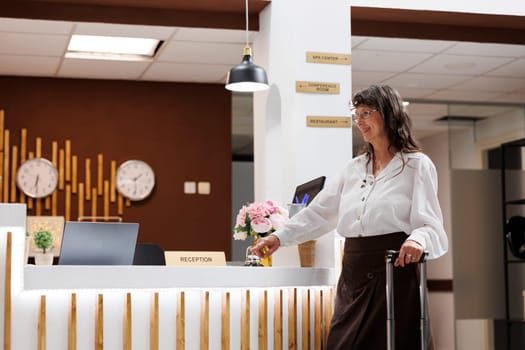 Elderly woman rings hotel concierge bell