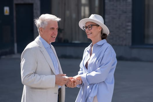 Stylish elderly laughing couple on a walk. Romantic relationships of mature people.