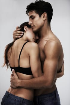 Couple, body and hug with skin in studio, topless and sensual with tender moment on white background. People together for fashion or beauty with intimacy, wellness and embrace, love and romance