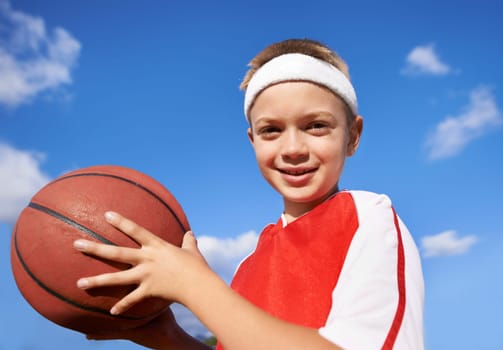 Happy boy, portrait and basketball for sports game, match or competition with blue sky background. Face of male person, child or player smile with ball for outdoor competition or practice in nature