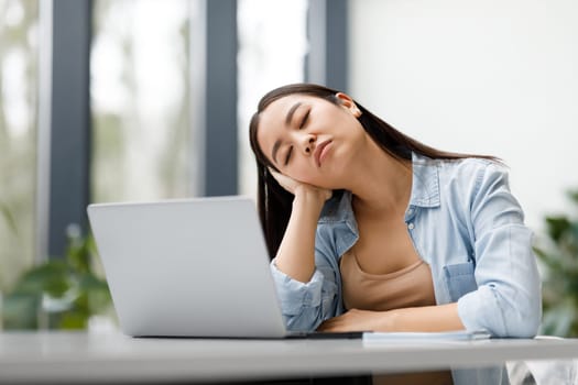 Educational exhaustion and overwork. Exhausted asian student lady sleeping in front of laptop tired of online learning
