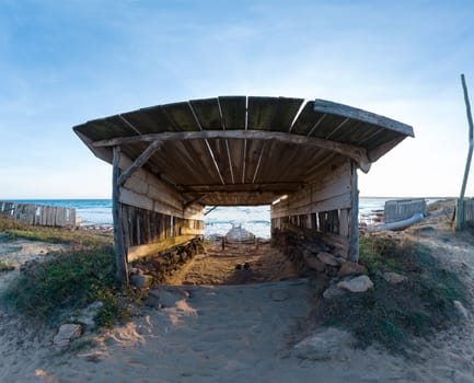 Wooden Boathouse and Rails at Sunset on Secluded Beach