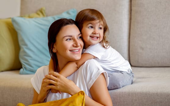 Portrait Of Happy Young Mother And Her Cute Little Daughter Embracing At Home, Smiling Caucasian Mom And Preschool Female Child Relaxing And Having Fun Together In Living Room, Copy Space