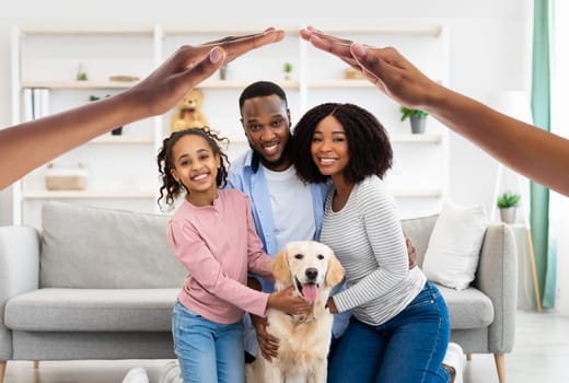 Happy black family posing with dog at home