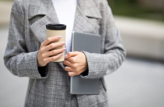 Cropped Shot Of Lady Holding Tablet And Coffee Cup Outside