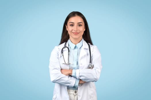 Confident female doctor with stethoscope on blue background