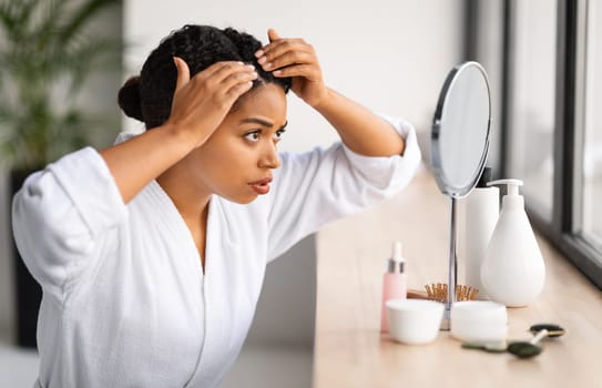 Dandruff Problem. Upset Black Woman Looking To Mirror At Her Hair Roots
