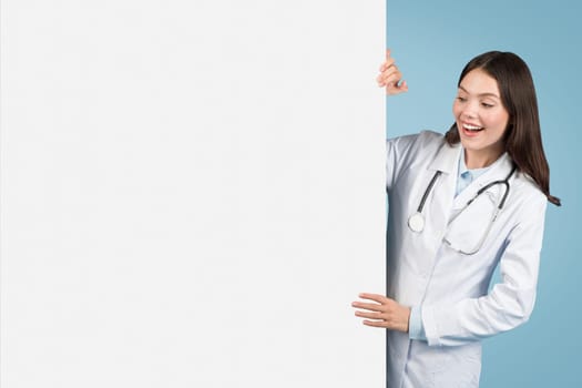 Excited doctor presenting blank board for medical ads