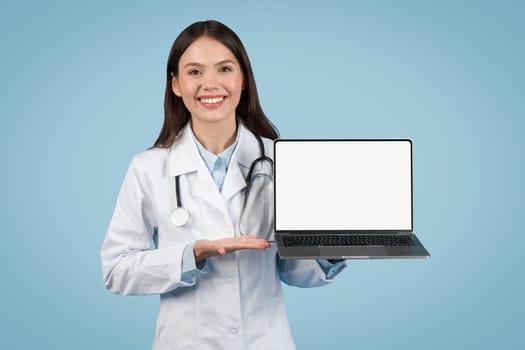Doctor woman presenting laptop with blank screen