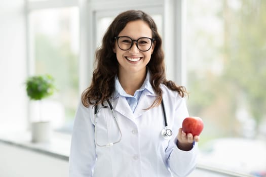 Positive brunette woman wearing medical coat and eyeglasses doctor