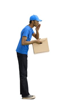 A male deliveryman, on a white background, full-length, with a box, tells a secret