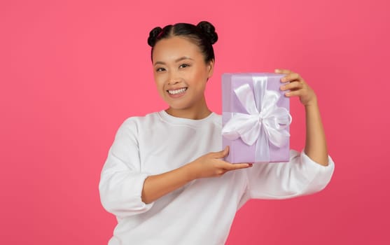 Happy beautiful asian female holding wrapped gift box
